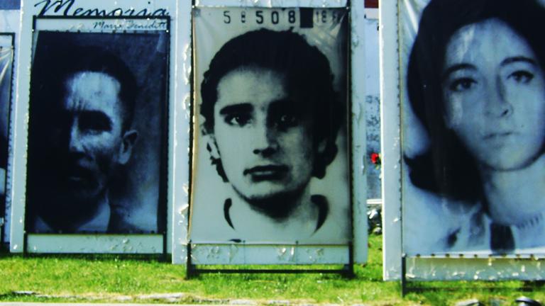Outdoor display of large photographs of people’s faces. Visibilité masquée.