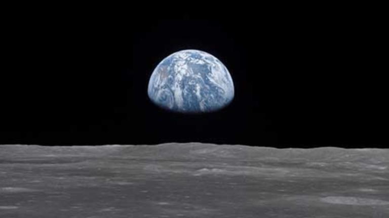 View of earth rising above the lunar horizon, showing the blue and white planet against the dark backdrop of space as seen from the moon’s surface. Visibilité masquée.