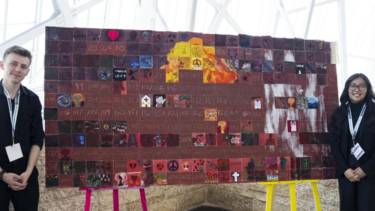 Un jeune homme et une jeune femme se tiennent devant une fresque composée de nombreux carrés. Certains carrés sont remplis d’images, tandis que d’autres sont remplis d’un fond marron, attendant d’être remplis.