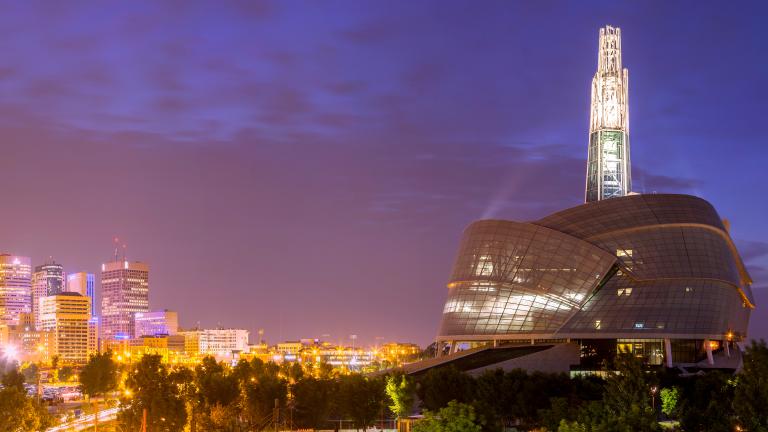 Une vue panoramique du Musée et de la ligne d’horizon de Winnipeg au crépuscule. Visibilité masquée.
