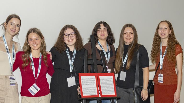 Un groupe de jeunes femmes se tient derrière un jeu de marelle. Les derniers carrés numérotés sont bordés de rouge, comme du sang.