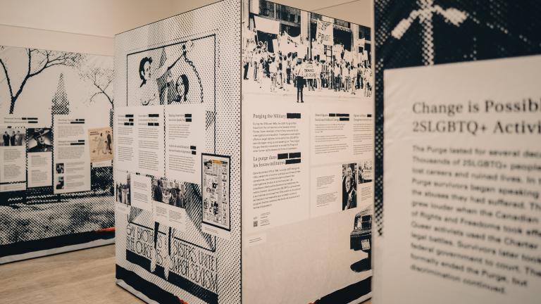 Une exposition pop-up présentant trois panneaux distincts en forme de cube noir et blanc. Le plus proche affiche « Le changement est possible ». Visibilité masquée.
