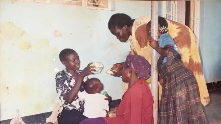 Grace (première à partir de la gauche) réunie avec sa famille après sa fuite de la LRA, Lira, Ouganda, 2004. Sa fille de 14 mois, née en captivité, est assise sur ses genoux.