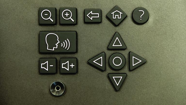 Une prise de type pour écouteurs et un clavier avec des symboles indiquant les commandes de volume, d'agrandissement et de navigation.