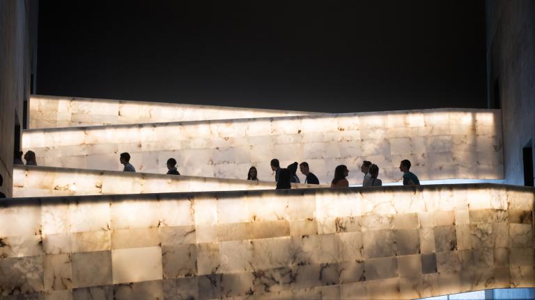 A group of people traveling up the Museum’s lighted alabaster ramps. Visibilité masquée.