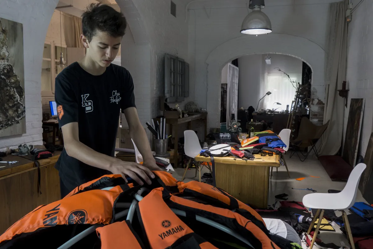 Un adolescent installe des gilets de sauvetage sur une structure en forme de dôme.