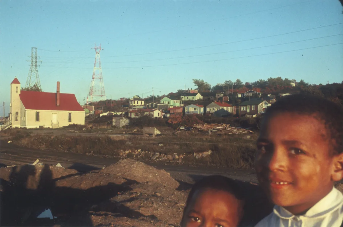 Deux enfants souriants regardent vers l’appareil photo.