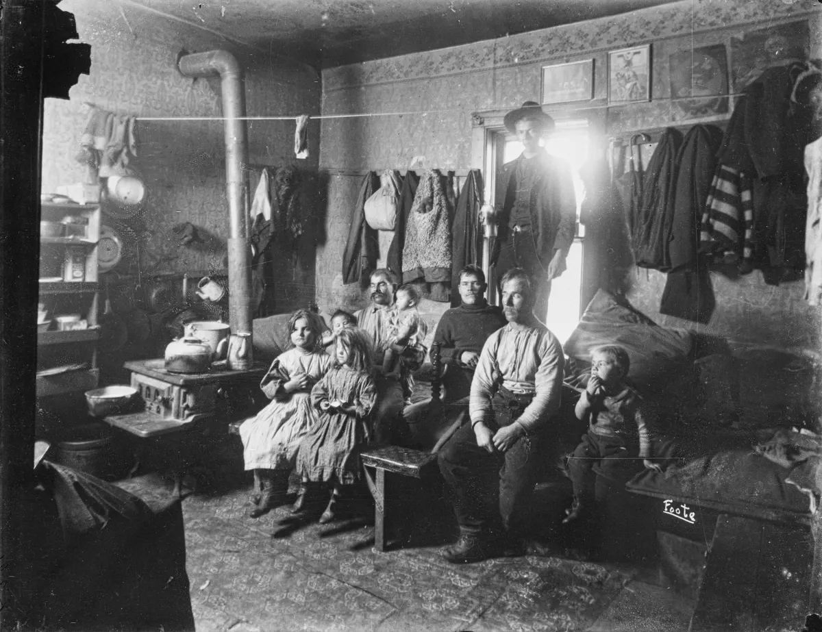 Une grande famille assise dans un espace exigu.
