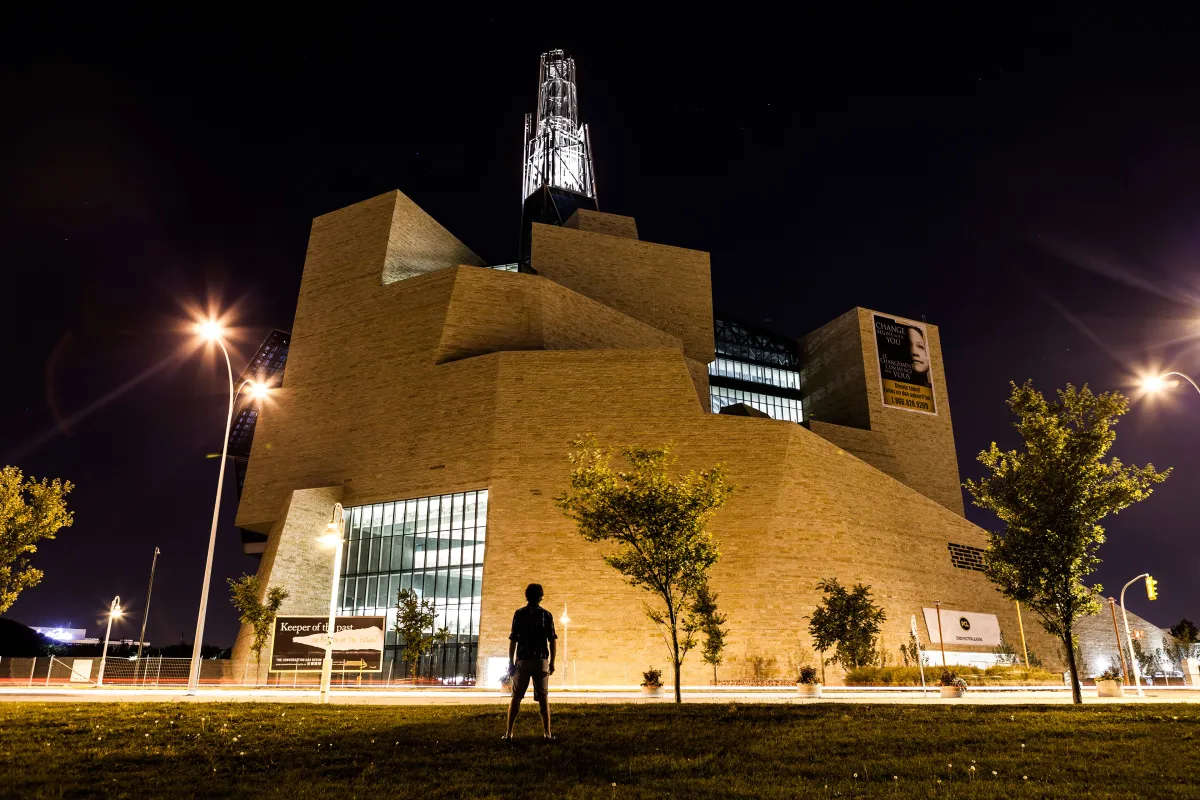 Une silhouette d'une personne qui fait face au Musée durant la nuit.