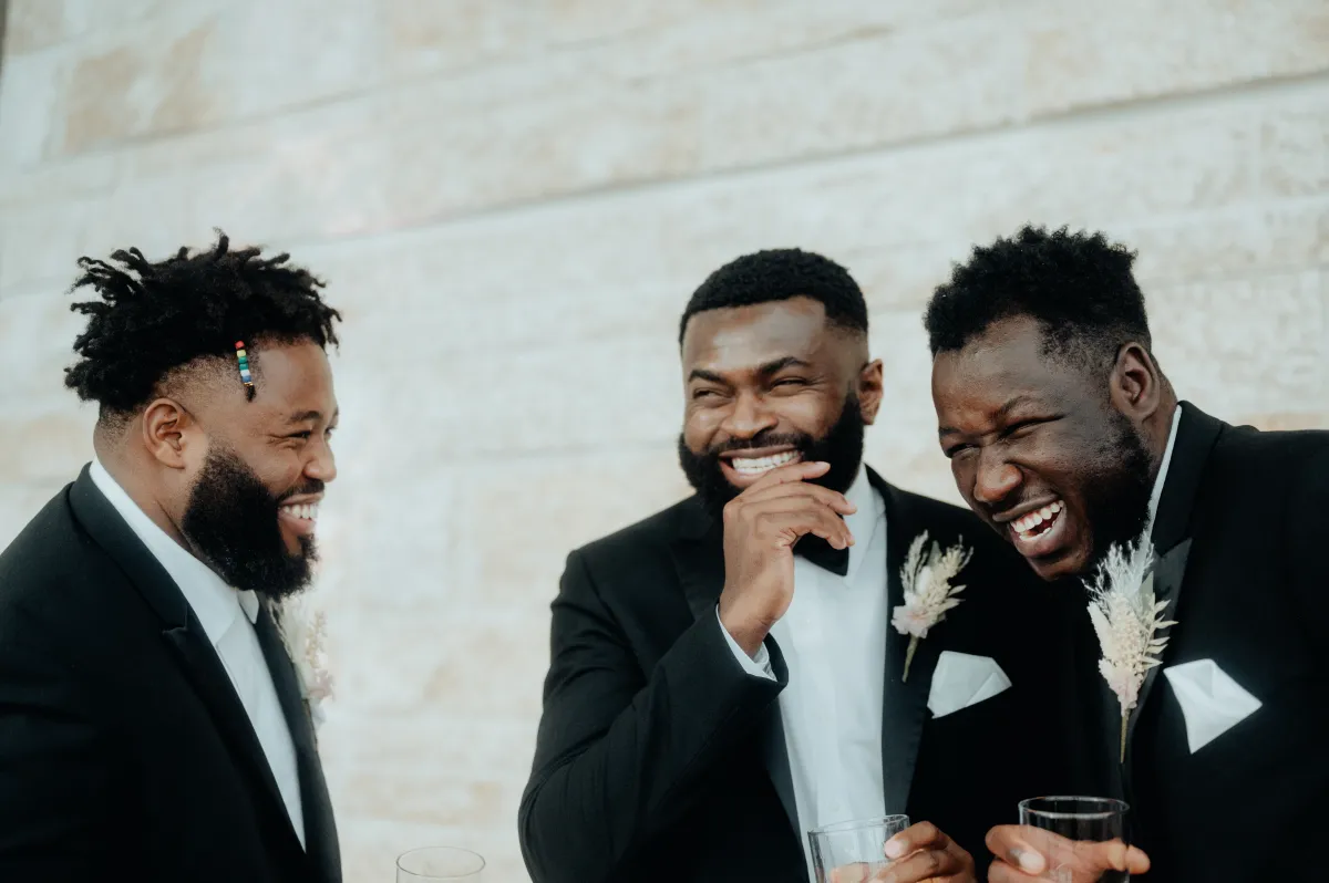 Trois hommes en smoking rient.