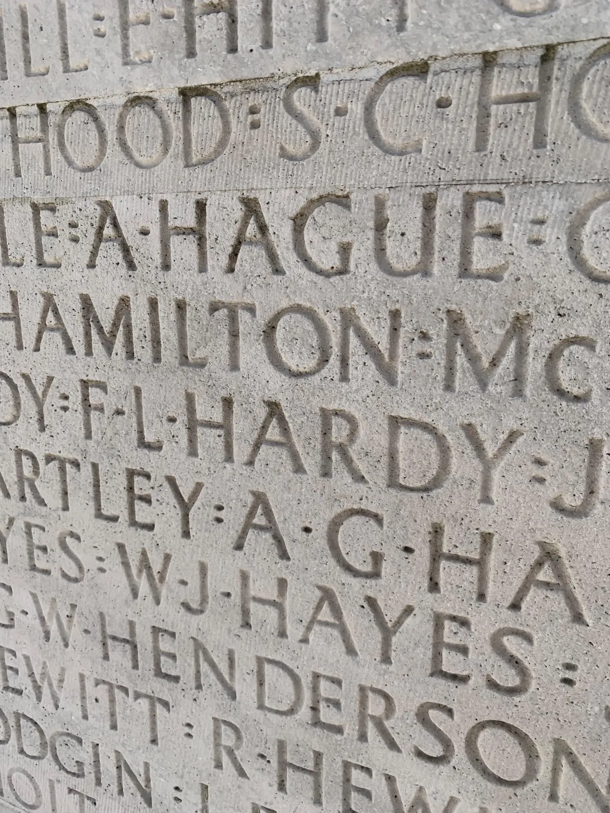 Gros plan sur de nombreux noms gravés en lettres majuscules dans de la pierre grise. Le seul nom complet, visible au centre, est « F L HARDY ».