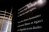 Du texte blanc en grand format sur un mur noir : « Tous les êtres humains naissent libres et égaux en dignité et en droits. »