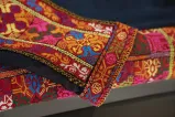 Gros plan sur un tissu brodé coloré. Le motif est une broderie traditionnelle palestinienne appelée tatreez.