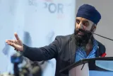 Image en buste de Pardeep Singh Nagra parlant au microphone. Il regarde vers sa droite, bras droit tendu, paume vers le haut.