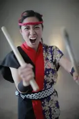 Une femme tambour tient ses bâtons dans ses mains.