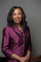 Une femme noire sourit vers l’objectif.