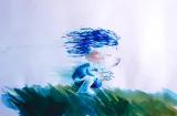 Une image fixe tirée d'un film d'animation. Un petit enfant aux cheveux bleus balayés par le vent est accroupi dans l'herbe.