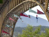 Plusieurs grandes bannières triangulaires sont suspendues au bas d’un grand pont.