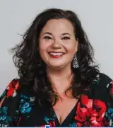 Femme avec des cheveux foncés longueur d'épaule et un haut à fleurs.
