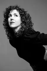 Portrait en noir et blanc d’une femme aux cheveux bouclés de la longueur des épaules.