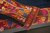 Gros plan sur un tissu brodé coloré. Le motif est une broderie traditionnelle palestinienne appelée tatreez.