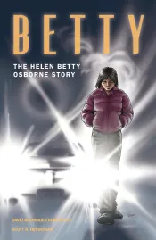 La couverture d’un roman illustré intitulé « Betty: The Helen Betty Osborne Story », qui montre une jeune femme en vêtements d’hiver avec les phares d’une voiture derrière elle.