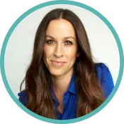 Une femme d’âge moyen aux longs cheveux foncés porte un chemisier bleu.