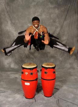 Une personne sautant dans les airs au-dessus de congas.