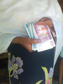 Les mains d’une femme rohingya tenant des billets de « kyats » (prononcé « tchat »), unité de monnaie du Myanmar.