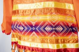 Cette partie de la robe orange à clochettes est constituée de multiples rubans colorés.