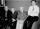 Quatre hommes assis sur un sofa qui regardent l’appareil-photo.