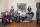 Une famille de six personnes souriantes dans un salon.