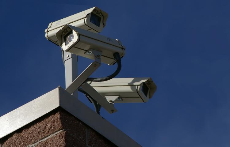 Trois caméras de surveillance sur le coin d'un bâtiment Visibilité masquée.
