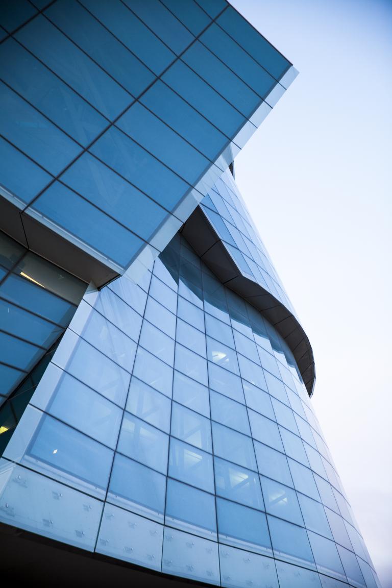 Un gros plan des grands panneaux de verre qui enveloppent la moitié du Musée.