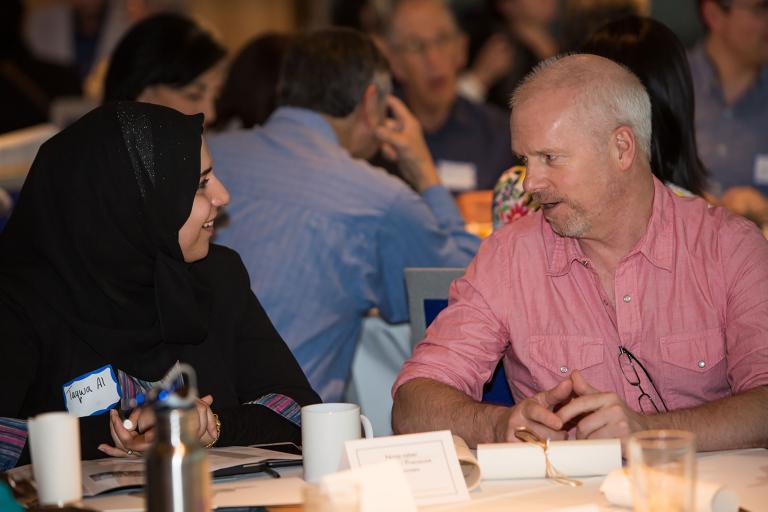 Two people talking at a table. Visibilité masquée.
