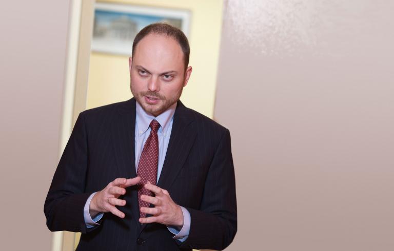 Un homme qui parle, les bras pliés aux coudes et les mains levées, ouvertes l’une face à l’autre. Visibilité masquée.