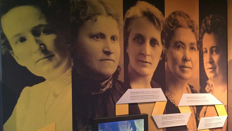 Grandes photographies de cinq femmes sur le mur d'une exposition du Musée. Il s'agit des « Célèbres Cinq » - Nellie McLung, Emily Murphy, Irene Parlby, Louise McKinney et Henrietta Edwards. Visibilité masquée.