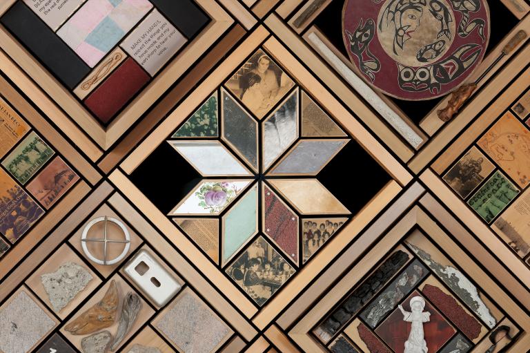 Portion d'une grande oeuvre d'art composée d'objets placés dans des cadres en cèdre. Visibilité masquée.