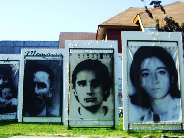 Outdoor display of large photographs of people’s faces. Visibilité masquée.