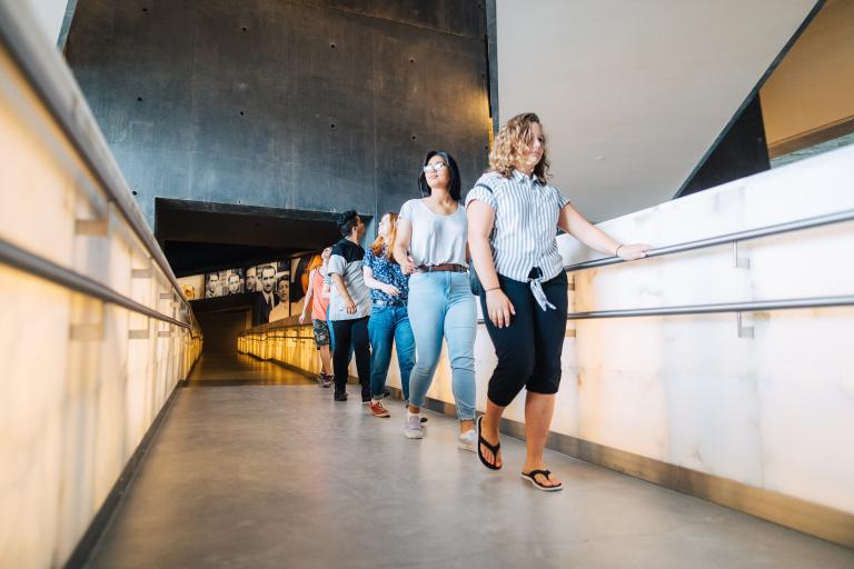 Des élèves marchant en file sur une rampe. Visibilité masquée.