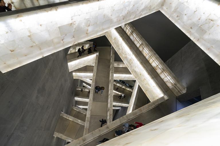 Une vue de personnes marchant sur des rampes illuminées.