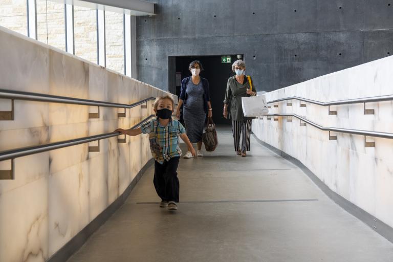People walking up a ramp in the museum. Visibilité masquée.