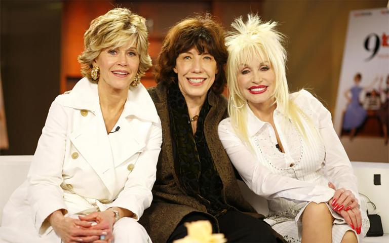 Jane Fonda, Lily Tomlin et Dolly Parton assises ensemble sur un divan. Visibilité masquée.
