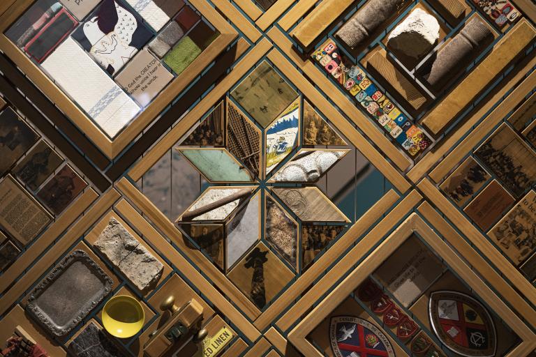 De nombreux morceaux de bois et d’autres matériaux sont disposés selon des motifs géométriques qui s’emboîtent et se répètent. Visibilité masquée.