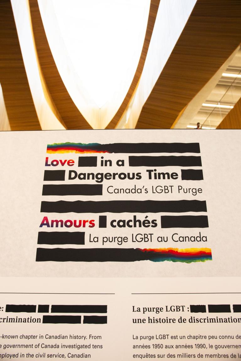 Texte d’une exposition sur la purge LGBT au Canada, intitulée « Love in a Dangerous Time » et « Amours cachés », avec des sections traitant de la discrimination et du contexte historique, illustrées par les couleurs de l’arc-en-ciel.