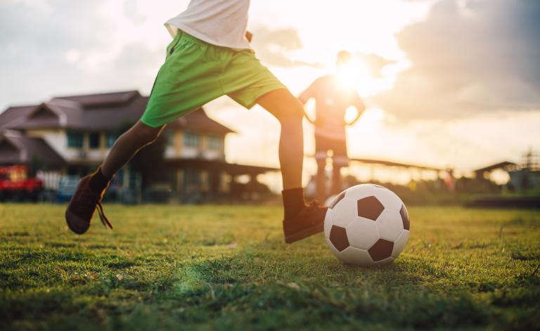 Soccer player on field getting ready to kick the ball. Visibilité masquée.
