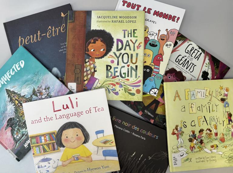 Des livres d’enfants sont répartis sur une table. Visibilité masquée.