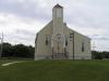 Image d’une église en bois à un seul clocher. Un panneau placé au-dessus des portes porte l’inscription « Seaview United Baptist Church ».
